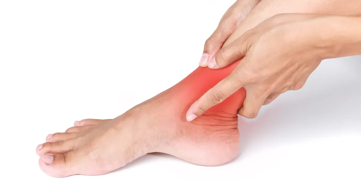 Person holding a painful ankle